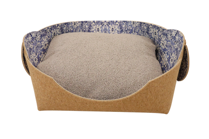Cozy pet bed made of cork with raised sides and a blue flower pattern cushion inside, designed for dogs and cats to sleep comfortably