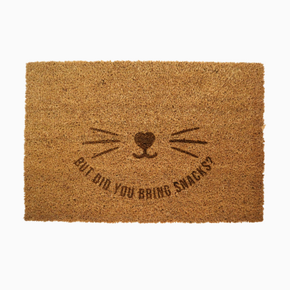 Doormat with cat face design and text 'But did you bring snacks?' on a white background