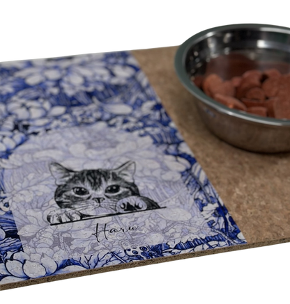 Cat-themed mat with a bowl of cat food on a white background
